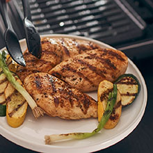A plate of freshly grilled vegetables and chicken breasts.